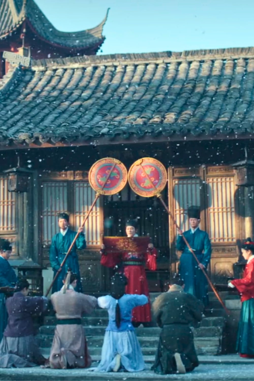 An imperial edict is being delivered by a eunuch to a merchant family in the snow