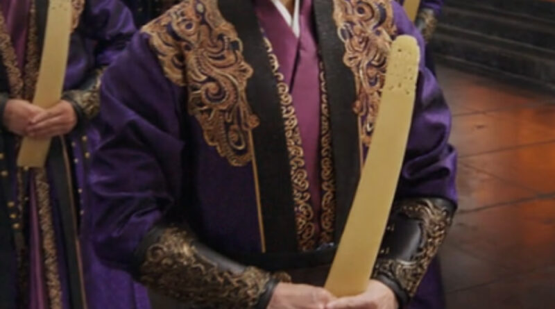 A scene from A Dream Within A Dream Chinese period drama of man in purple robes in court holding a jade plaque