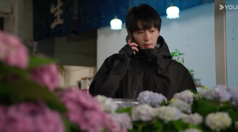 Affinity episode recap 33-34: Chinese sci-fi drama scene of on the phone with flowers in front of him