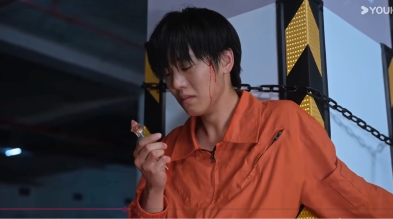 Affinity episode recap 7-8: Chinese sci-fi drama scene of a man in prison overalls eating a lollipop