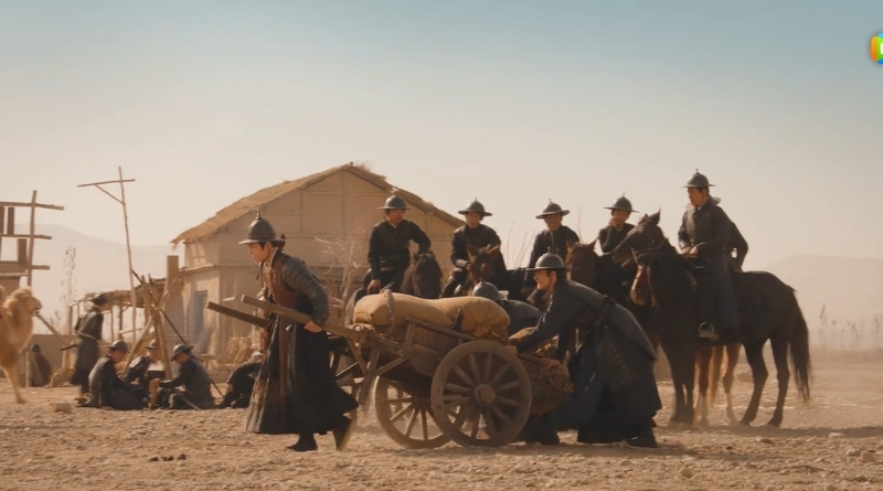 Scene from modern Chinese drama The Road To Splendor Episode 13 recap of soldiers hoisting a cart of sacks in the desert