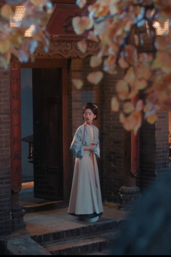 Scene from period Chinese drama The Road To Splendor Episode 15 recap and review of a woman in hanfu outside her house under the autumn tress