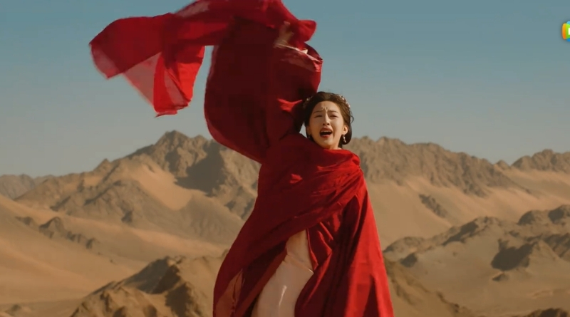 Scene from modern Chinese drama The Road To Splendor Episode 18 recap of a woman in red waving a scarf in the desert