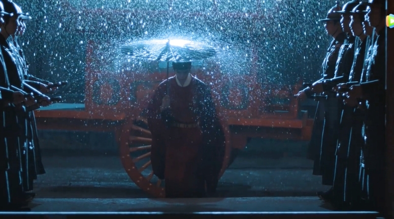Scene from modern Chinese drama The Road To Splendor Episode 19 recap of a man from the imperial court walking in the rain with an umrealla