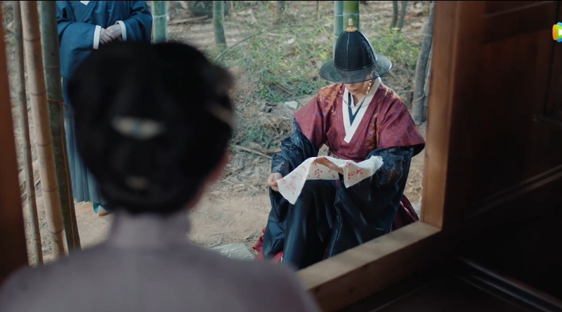Scene from modern Chinese drama The Road To Splendor Episode 24 recap of a man kneeling with a piece of cloth outside of a woman's window