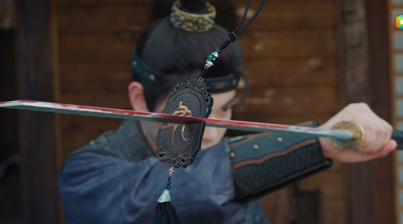 Scene from modern Chinese drama The Road To Splendor Episode 8 recap of man slashing a token in half with a sword