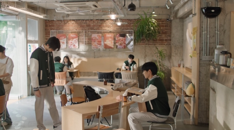 Scene from modern Chinese drama Road To Success Episodes 25-26 recap of 2 male students in a cafe with one boy trying on a pair of shoes