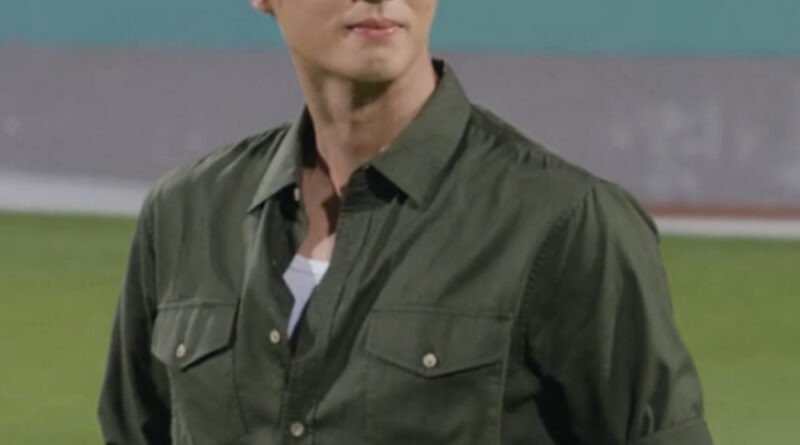 Scene from modern Chinese drama Road To Success Episodes 31-32 recap a man in a green shirt, smiling while standing in a stadium