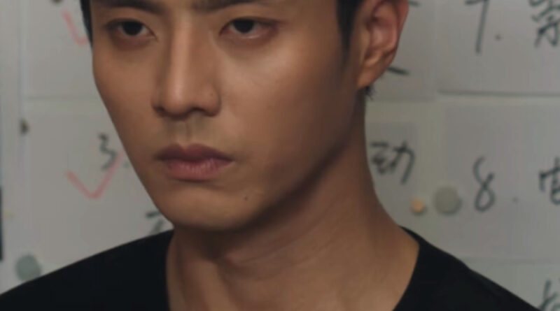 Scene from modern Chinese drama Road To Success Episodes 5-6 recap of a man in a black tshirt with a wall of information behind him