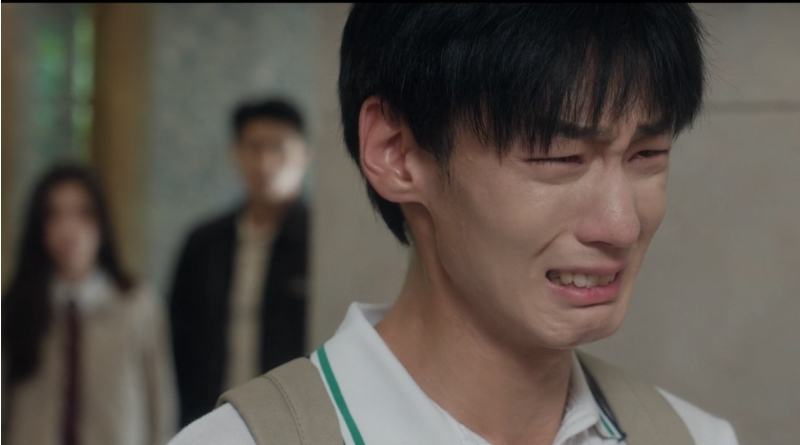 Scene from modern Chinese drama Road To Success of a male student crying while their teachers are standing behind him, watching on
