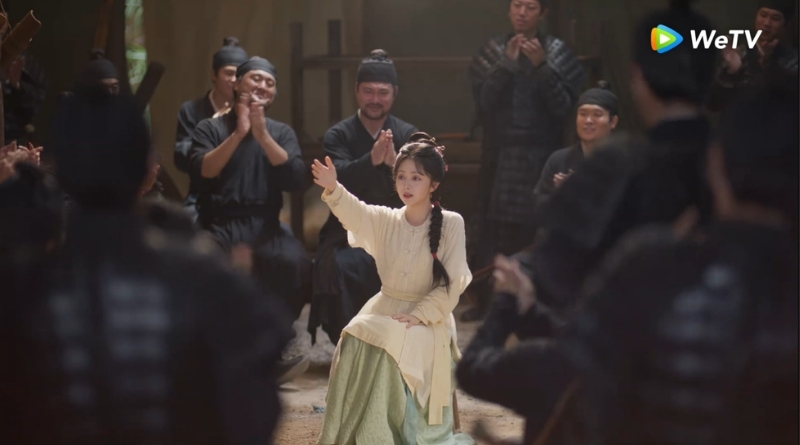 Scene from period Chinese drama Against The Current (2026) Episode 14 Recap and review of a woman in light yellow dress telling a story to soldiers