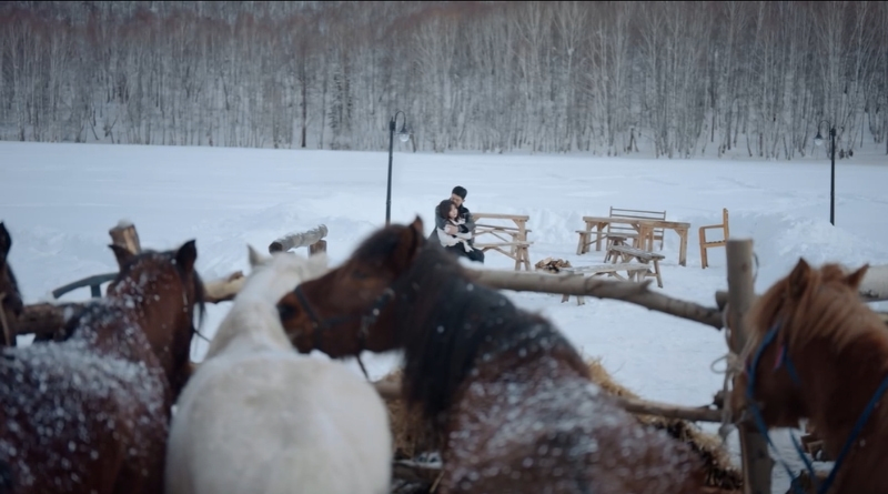 Scene from modern Chinese drama Road Home Episode 12 recap and review of a couple cuddling in the remote snow area of China with horses in an open stable