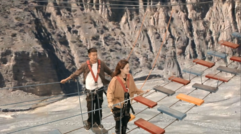 Scene from modern Chinese drama Road Home Episode 22 recap and review of a couple walking a planked bridge to see mountain views