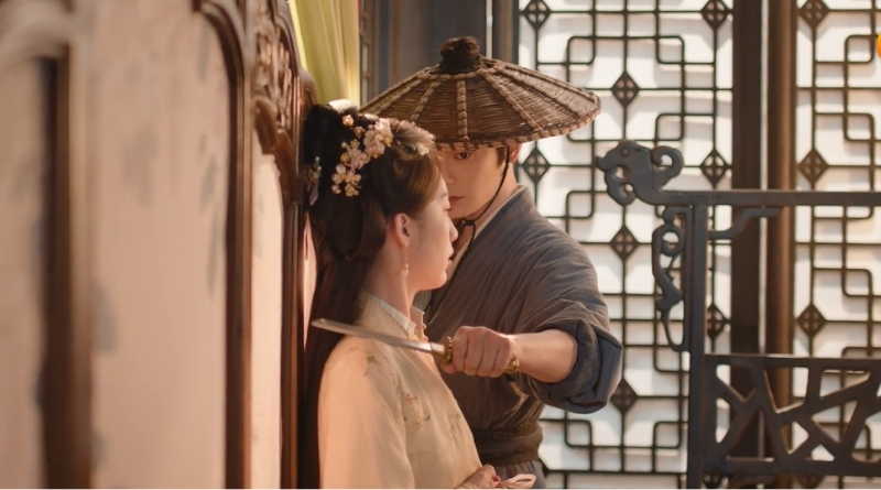 A scene from The Road To Splendor Romance Review and Recap (2026) of a man holding a knife to a woman's throat