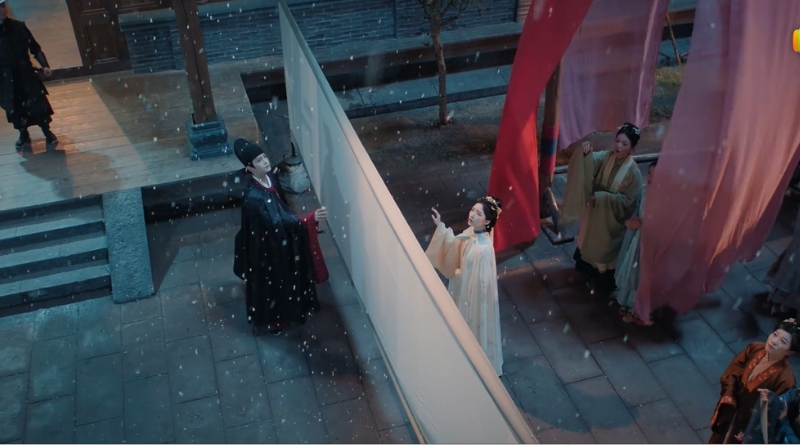 A scene from The Road To Splendor Romance Review and Recap (2026) of two people divided by a screen with their hands reaching out as it starts to snow