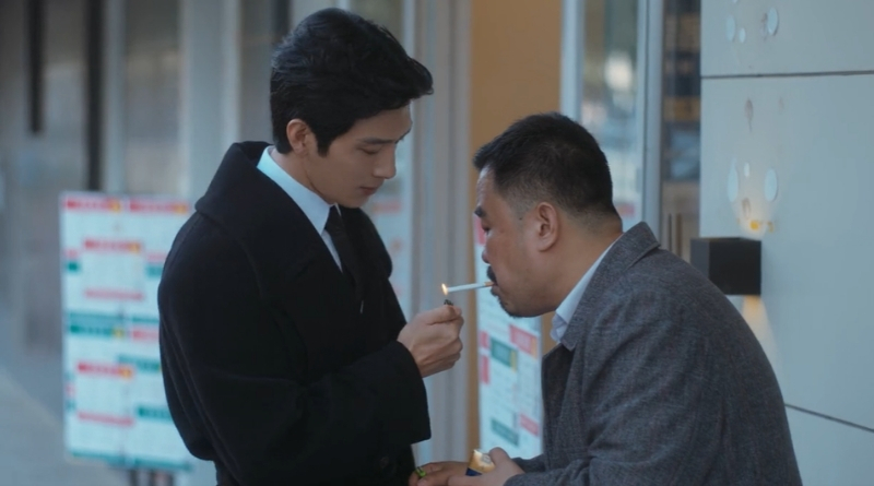 Scene from modern Chinese drama The Early Spring Episode 14 recap and review of a man in a suit lighting a cigarette for another man