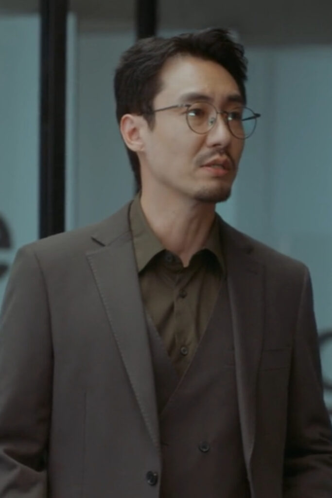 Scene from modern Chinese drama The Early Spring Episode 15 recap and review of a man with glasses in a brown suit