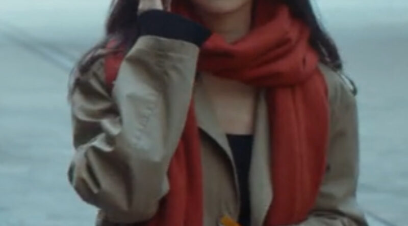 Scene from modern Chinese drama The Early Spring Episode 20 recap and review of a woman in a beige trench coat and a red scarf talking on her phone