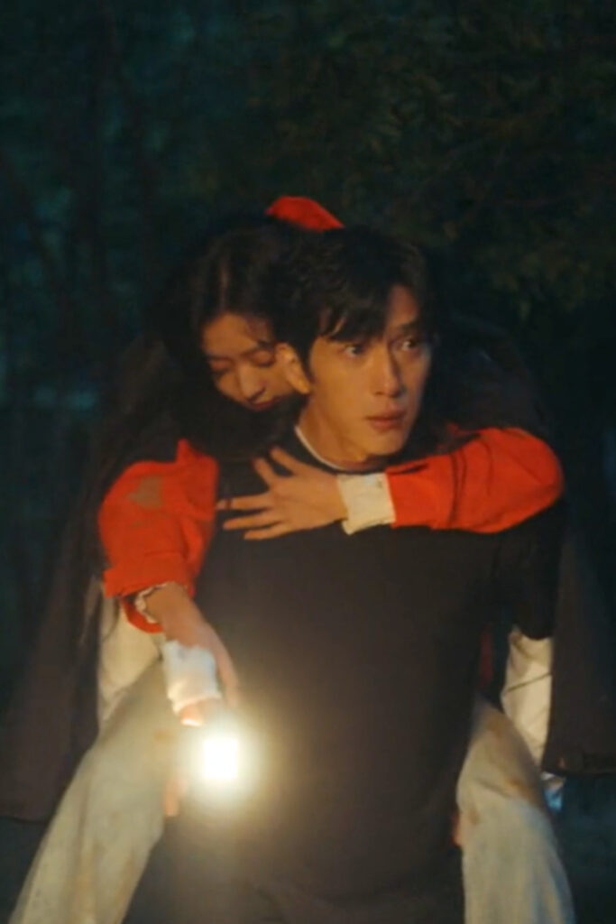 Scene from modern Chinese drama The Early Spring Episode 3 recap and review of a man piggybacking a woman in a red jacket down a mountain