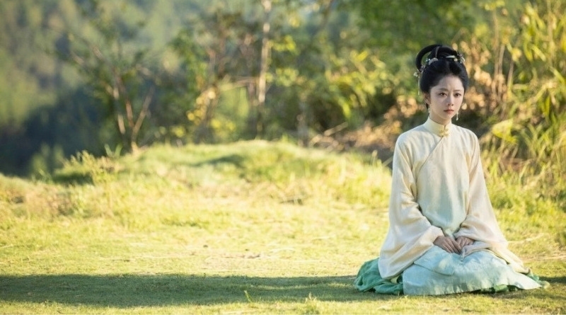 Against The Current Romance Review (2026) scene of a woman kneeling in an open grass space