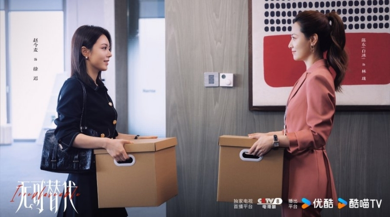 Scene from modern Chinese drama Irreplaceable (2026) Episode 12 Recap and review of 2 female colleagues passing each other holding cardboard boxes and smiling