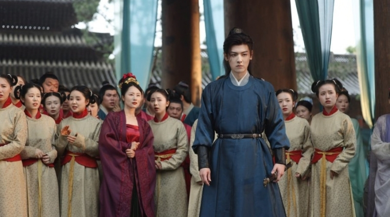 Scene from period Chinese drama Spring of The Blade (2026) Episode 23 Recap and review of a man in blue hanfu with a crowd of people behind him