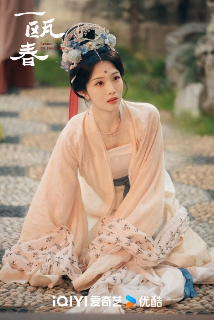 Scene from period Chinese drama Spring of The Blade (2026) Episode 3 Recap and review of a woman sitting on a pebbled floor outside