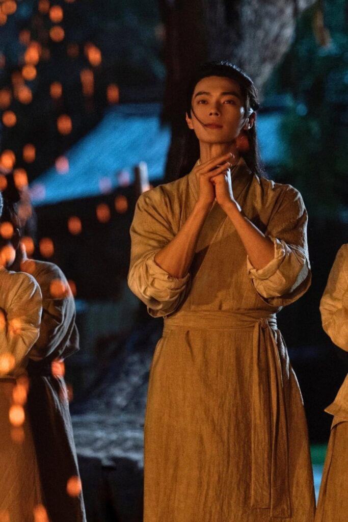 Scene from period Chinese drama Spring of The Blade (2026) Episode 30 Recap and review of a man in plain clothes in front of a bonfire and hands are together in thanks